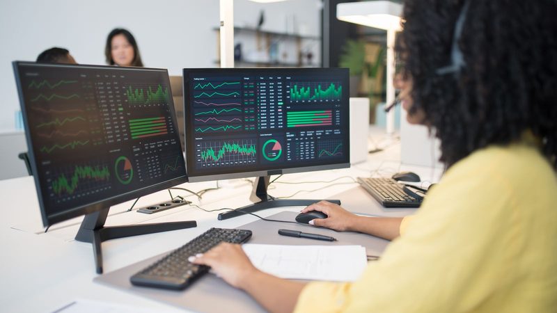 Analista revisando tableros de datos en varias pantallas para detectar anomalías