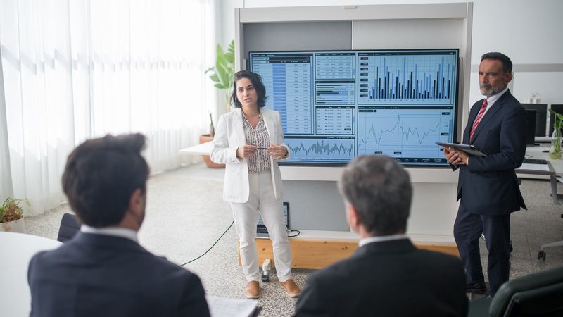 Equipo directivo analizando un tablero de datos en una sala de juntas