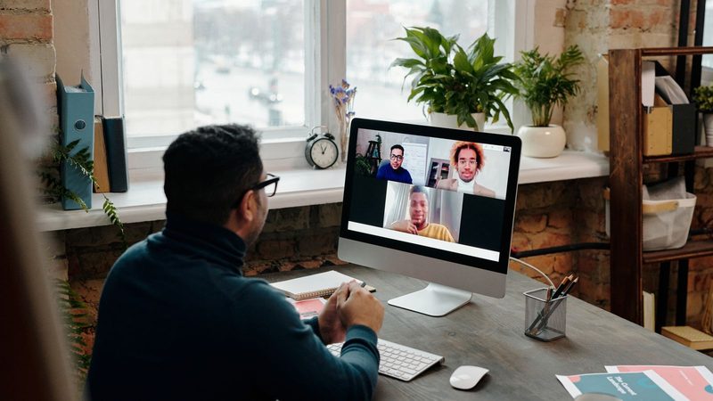 Profesional en videollamada con su equipo de trabajo desde una oficina en casa